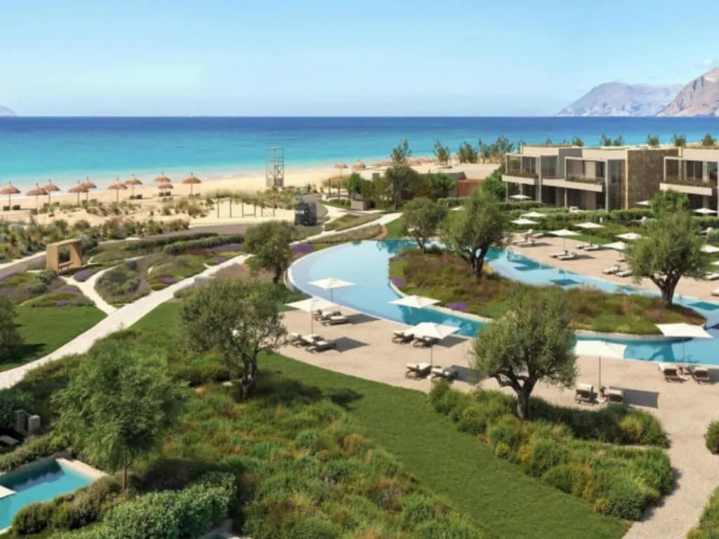 Panoramablick auf Poolanlage und Strand des Ikos Kissamos auf Kreta mit mediterraner Gartenlandschaft