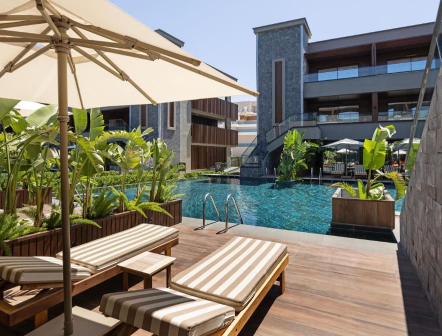 Swim-up-Poolbereich im Jacaranda Luxury Resort in Side mit modernen Gebäuden und Sonnenterrasse